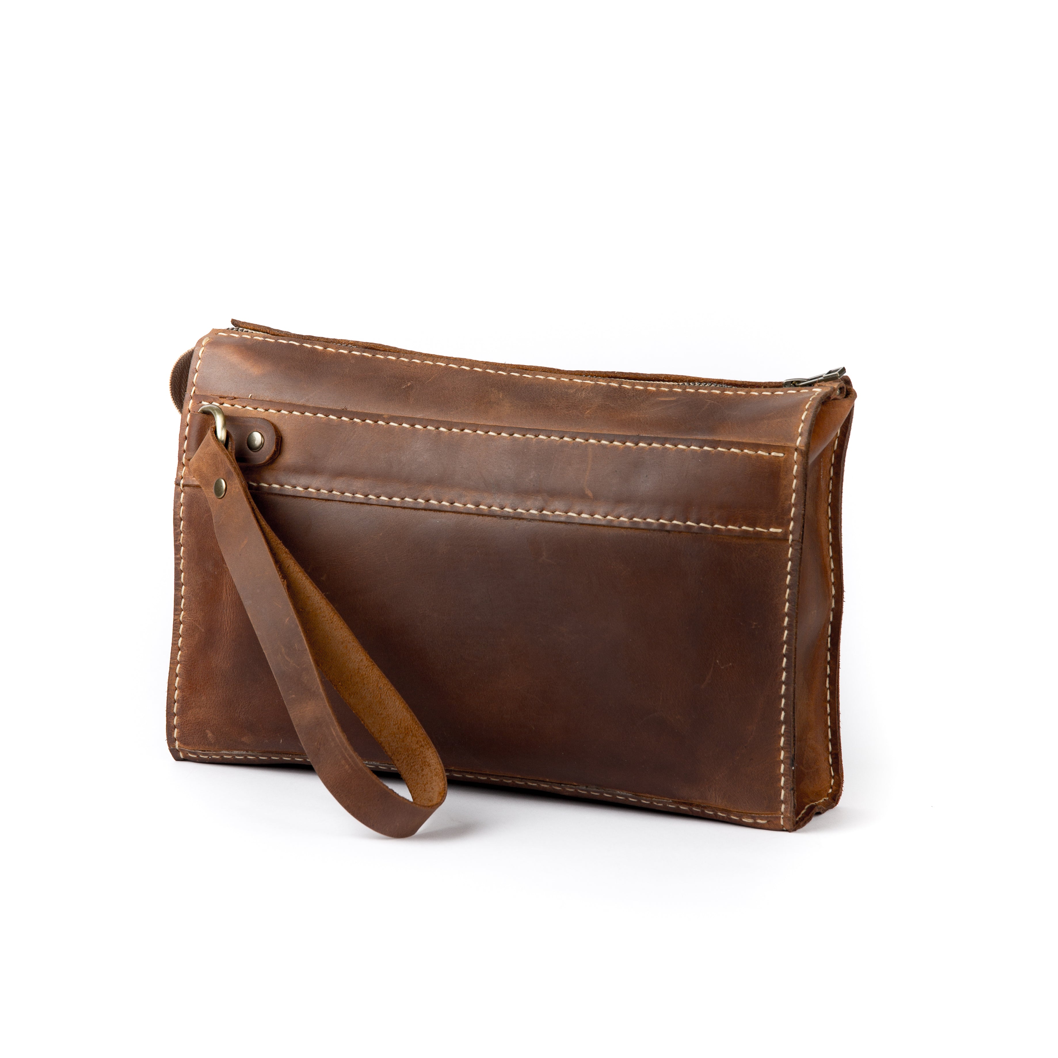 Handmade brown full-grain leather clutch with a wrist strap and white contrast stitching.