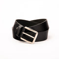 Photo of a casual black leather belt with a polished silver buckle, shown rolled on a clean white background, highlighting the premium natural leather texture and the sleek silver hardware.
