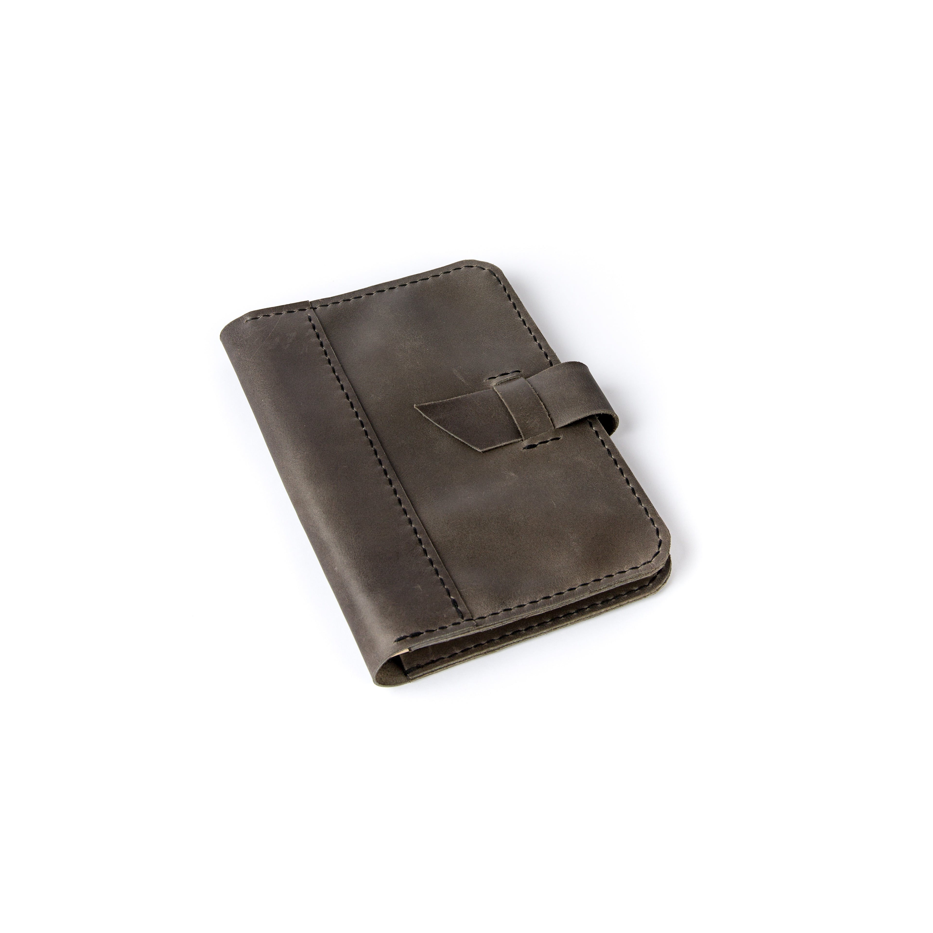 A dark brown full-grain leather A5 journal cover with hand-stitched edges and a strap closure.