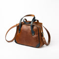 Side view of Lionell "Cairo Muse" handmade leather handbag in brown and blue, with shoulder strap attached.