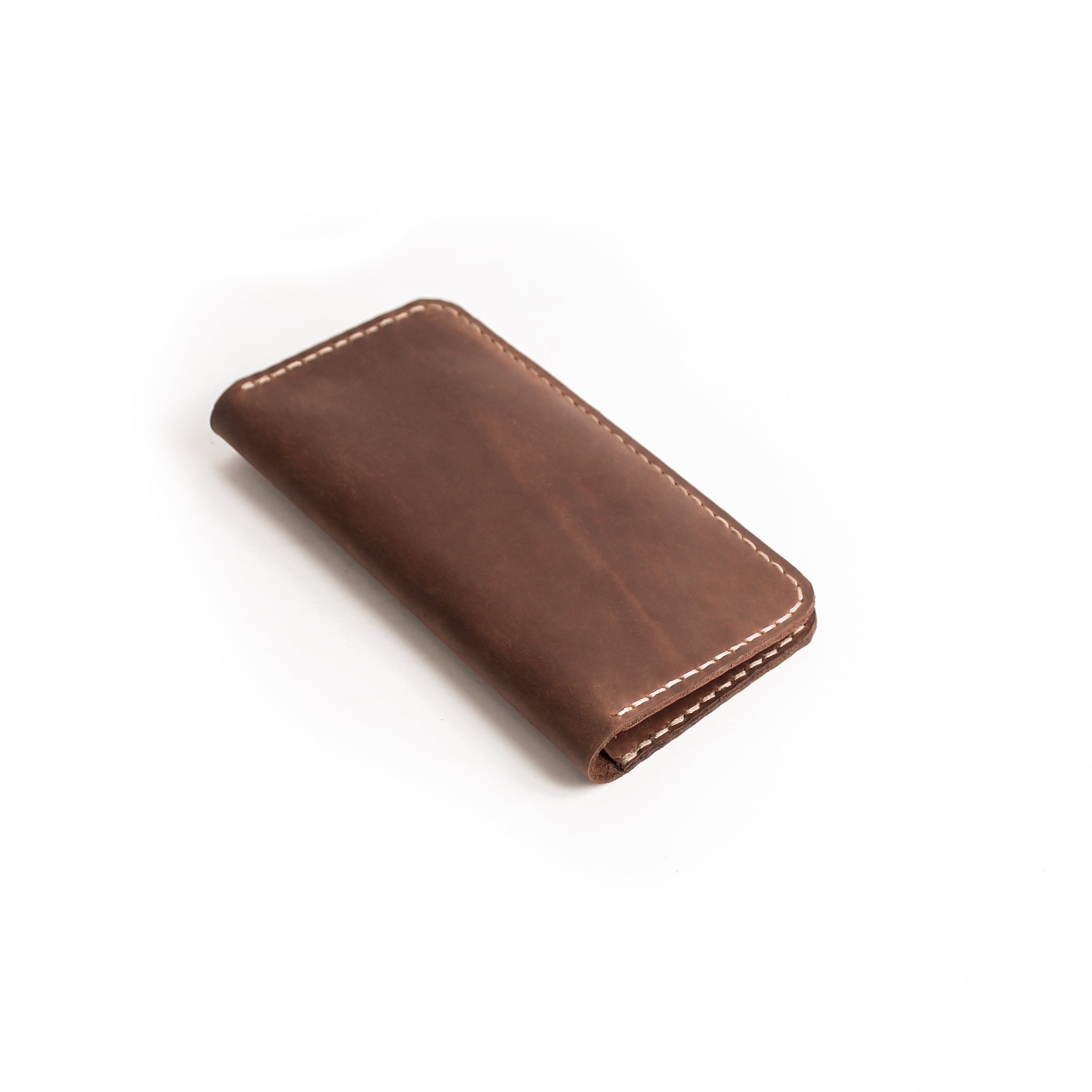 Lionell handmade brown leather long wallet closed. Minimalist slim design with durable stitching.