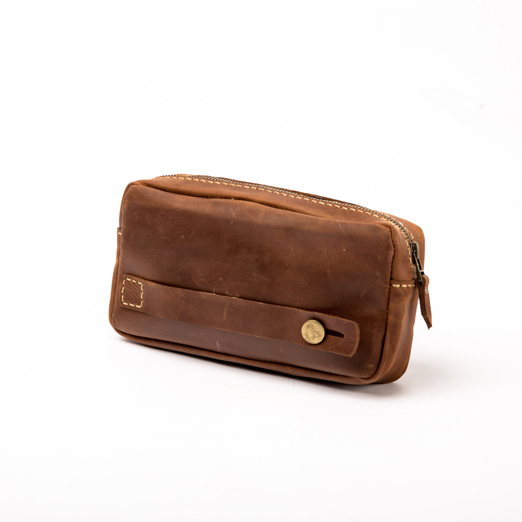 Back view of the LIONELL vintage brown leather handbag, showing a side leather handle with a brass-toned button and detailed handcrafted stitching, highlighting the craftsmanship and versatile carrying options.