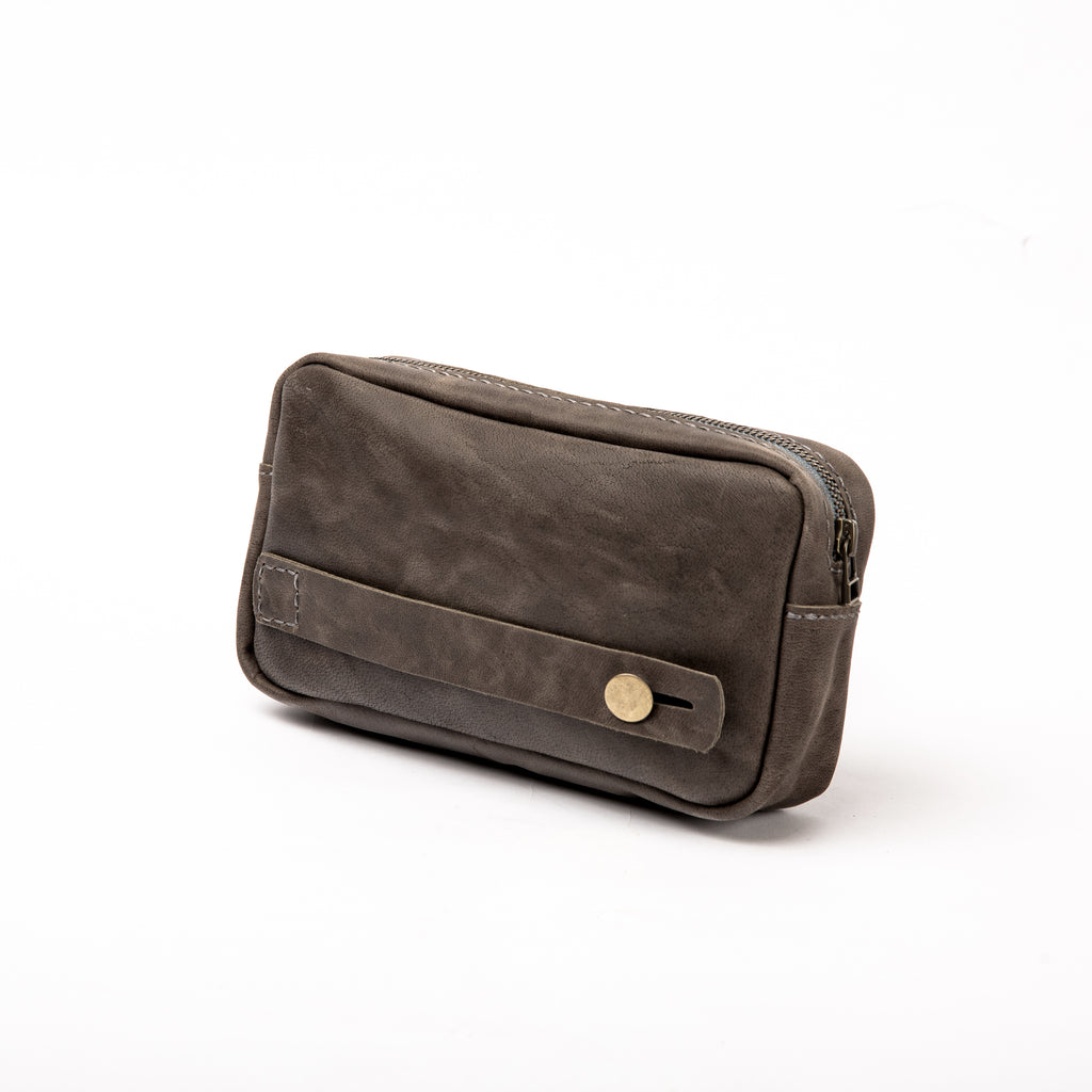 Back view of the LIONELL vintage grey leather handbag, showing a side leather handle with a brass-toned button and detailed handcrafted stitching, highlighting the craftsmanship and versatile carrying options.