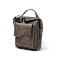 Front view of Lionell men's crossbody bag in vintage grey leather. Features a flap pocket and top handle.