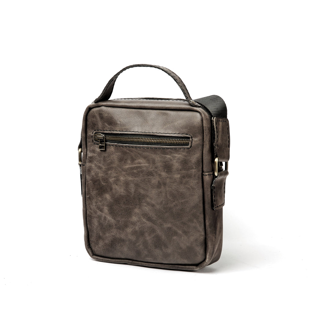 Back view of Lionell grey leather shoulder bag showing rear zipper pocket and durable strap attachments.