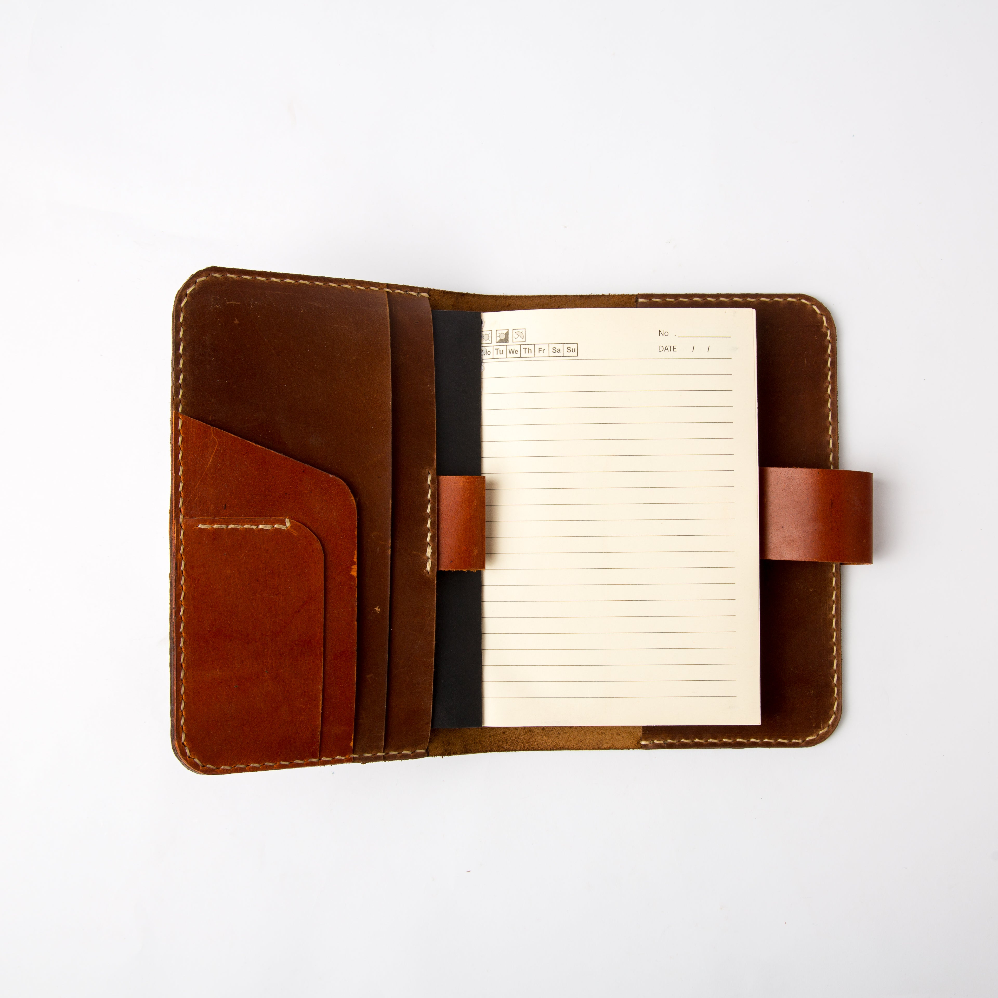 Open view of Lionell refillable leather notebook cover showing card slots, pen loop, and paper insert.