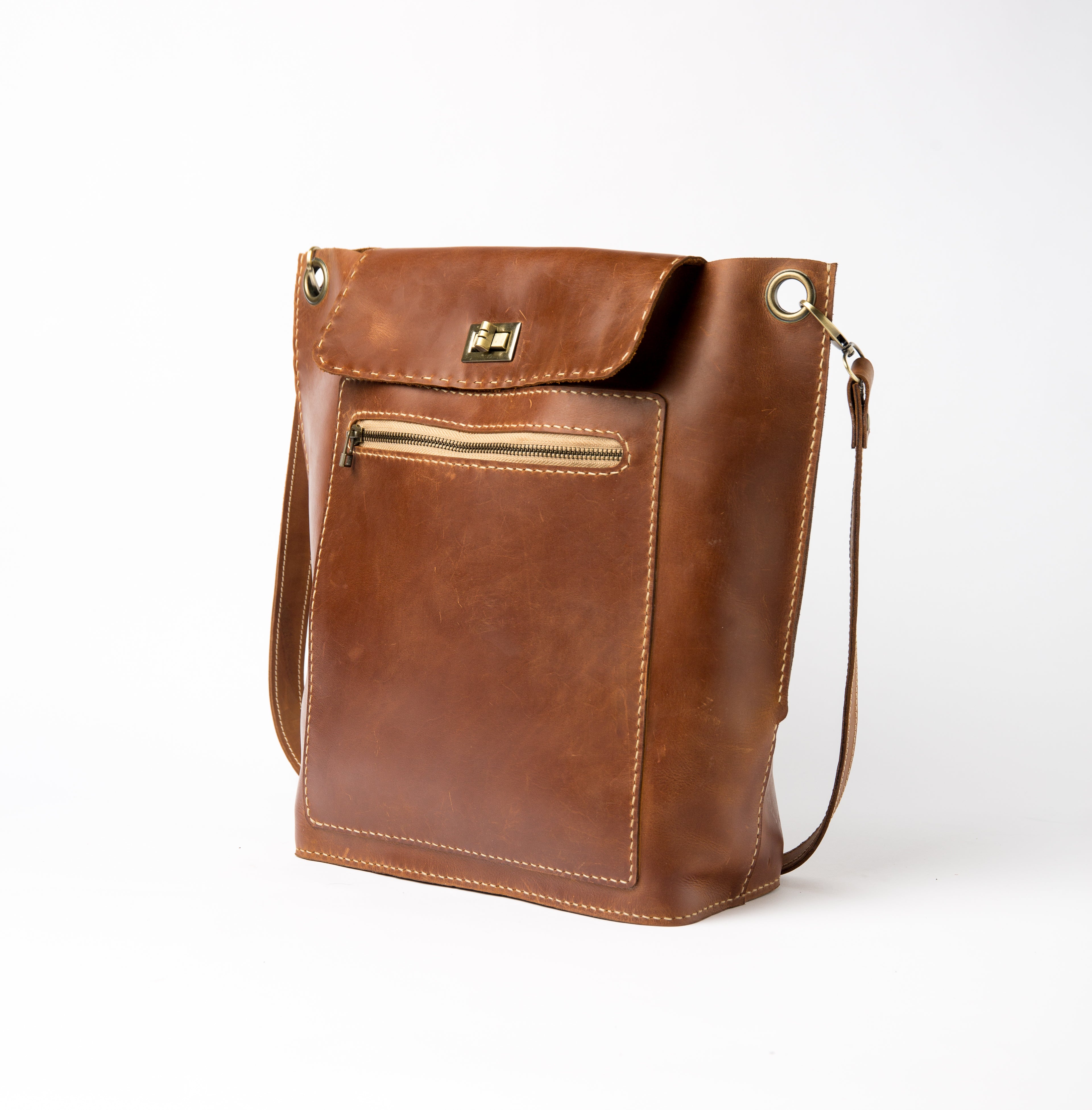 Front of Lionell "The Sphinx" handmade leather crossbody bag with front zipper pocket and brass turn lock.