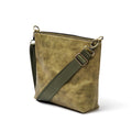 A side-view photo of 'The Urban Crossbag' by LIONELL; handcrafted from rich olive genuine leather, featuring a modern slim design with visible stitching and an adjustable dark olive fabric shoulder strap, displayed on a clean white background.
