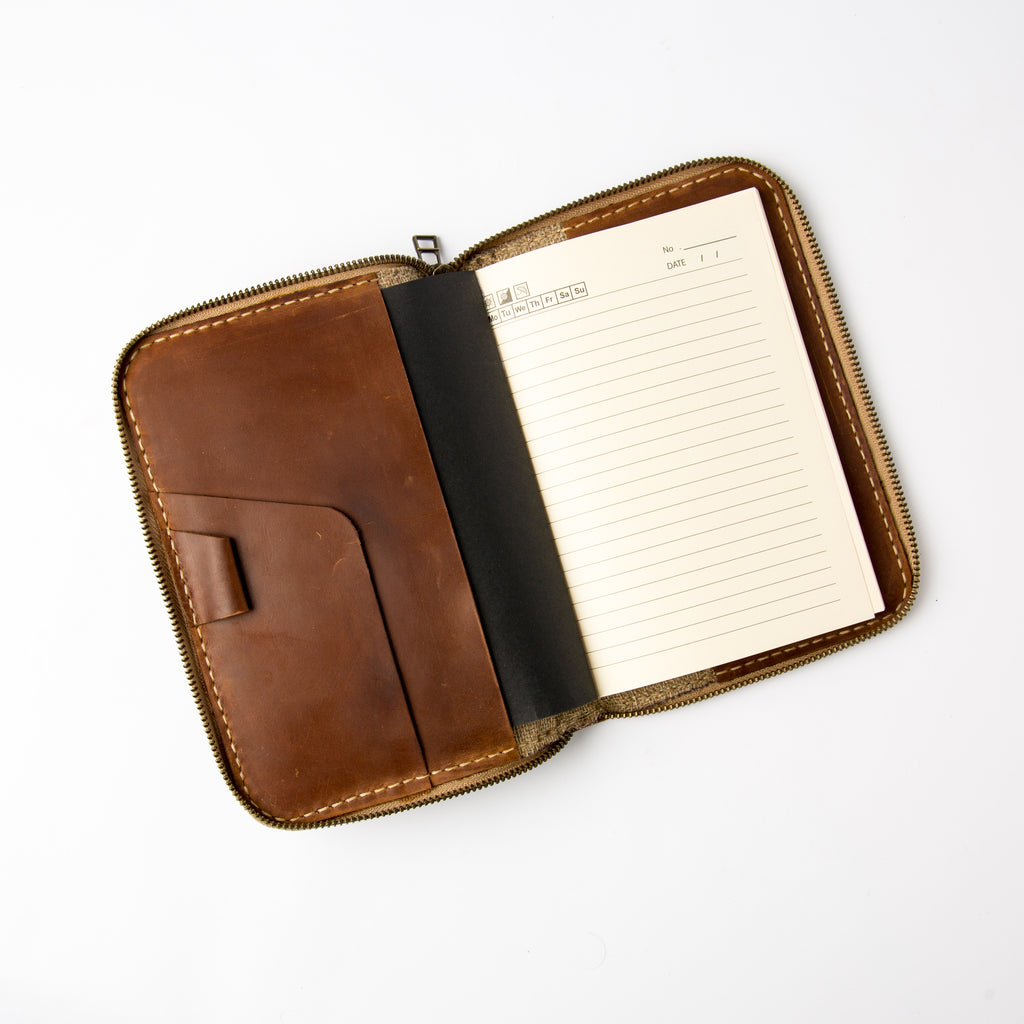 Front view of vintage brown refillable leather journal with zipper and interior pockets - Lionell.